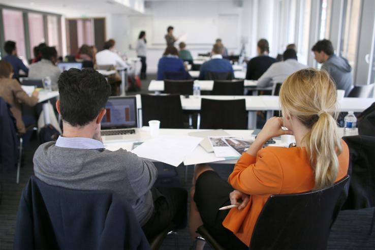 Back view of one man and one woman in a lecture hall