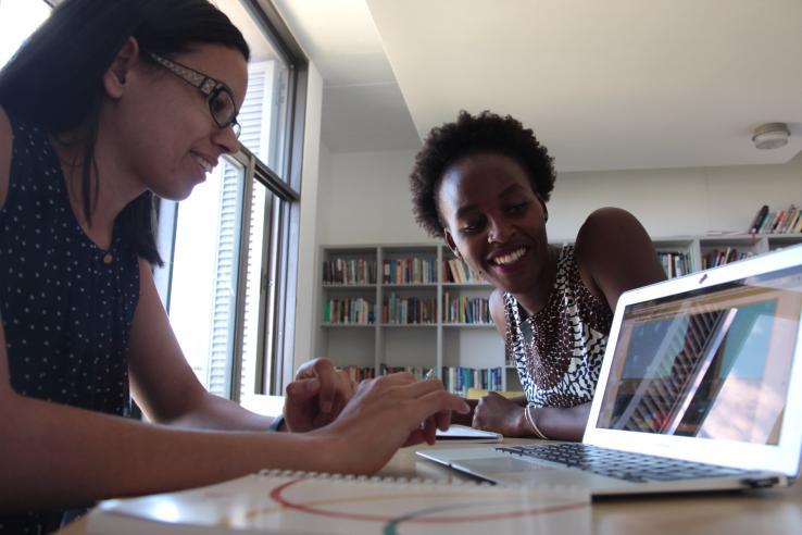 Two women sitting at a desk with a computer